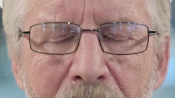 Close Up of Blinking Eyes of Old Businessman