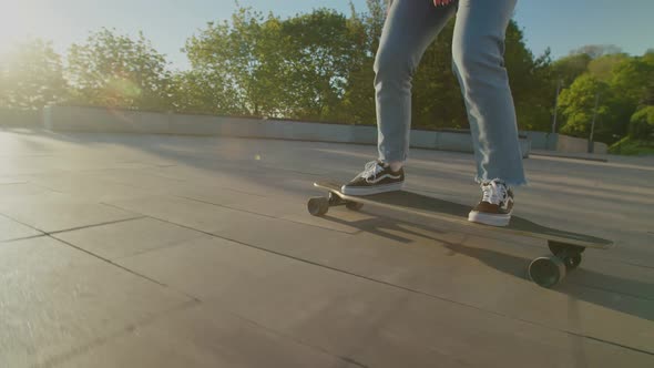 Woman Skateboarder Legs Riding Skateboard on City Street at Daybreak