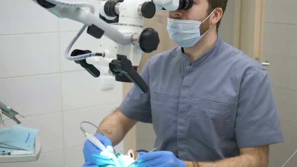 A dentist uses a modern electron microscope to treat dental caries in a dental clinic