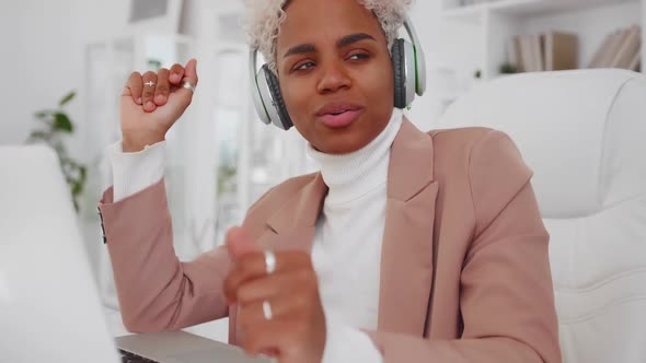Young African American Woman Freelancer Singing Listens to Music with Headset
