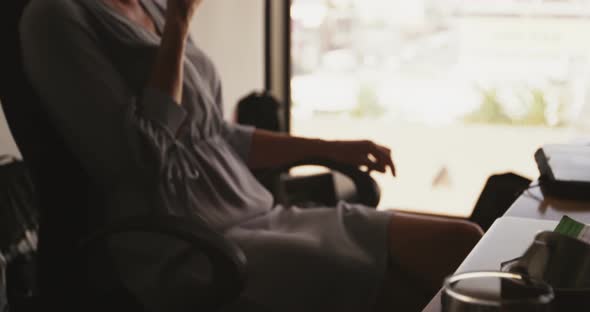 Businesswoman talking on mobile phone at desk 4k