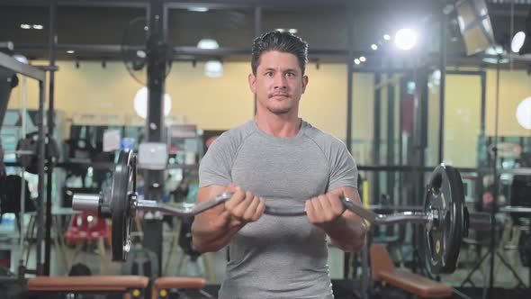 Caucasian Sportsman workout, exercise to maintain muscle and biceps in gym club lift up weight.