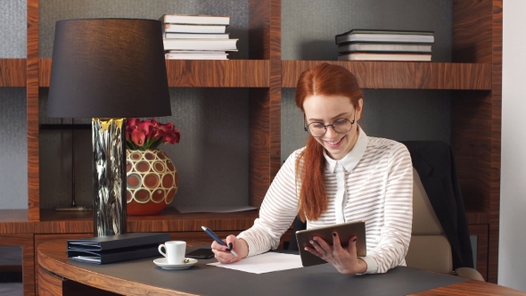 Stylish Redhead Girl Working at Home Office.