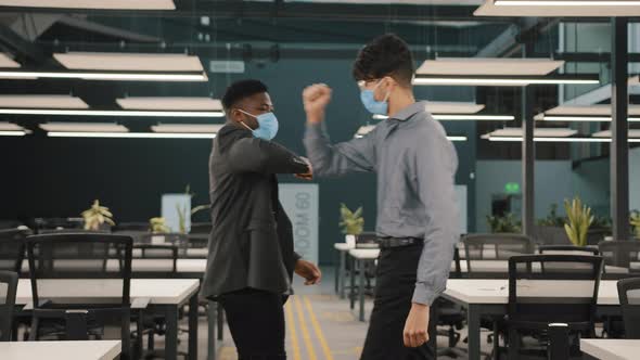 Two Multiracial Employees Friends African Man Greeting Arabian Colleague in Medical Face Masks Avoid