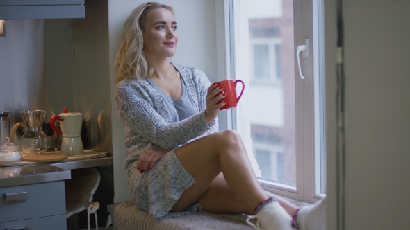 Woman with Mug Sitting on Window Sill