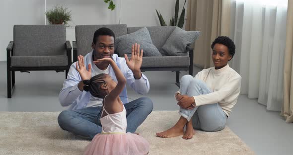 Afro American Black Ethnic Family Sitting at Home on Living Room Floor Young Parents Mom and Dad