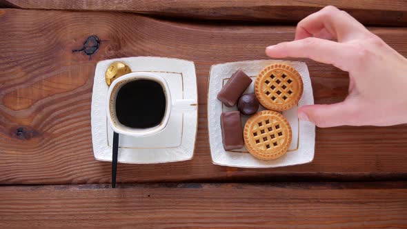 Steaming coffee cup and sweets on wooden table Restaurant menu Cookies chocolate candies on plate 4K