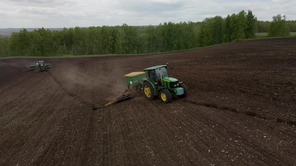 Aerial view of a tractor plowing the land on a cultivated farm field