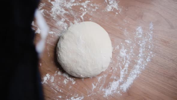 White flour dough is covered by a black cloth to be left to prove.