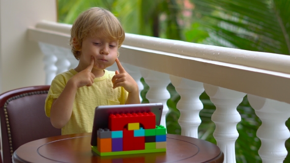 Boy in Tropics Talking with Friends and Family on Video Call Using a Tablet and Wireless Headphones