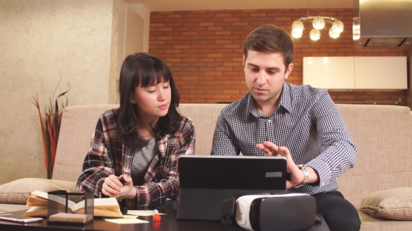 Young Business Couple Using Laptop at Home.