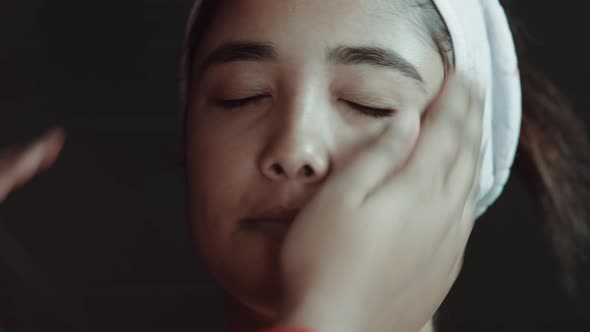 Close up of young beautiful woman and make up artist preparing her face for make up