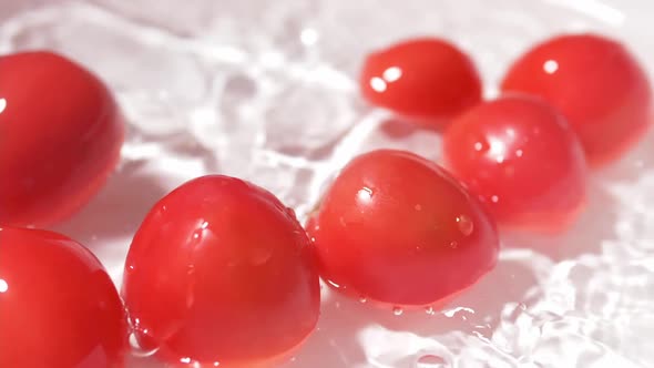 Small tomatoes on a white background, sanitized in water.