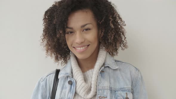 Afro American Girl in Casual Clothes Is Looking at Camera and Smiling