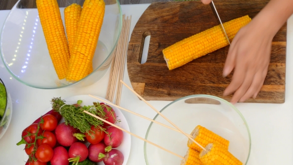 Hands Cut Corn Cobs Into Pieces