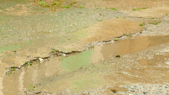 Child Having Fun in Rubber Boots in a Puddle