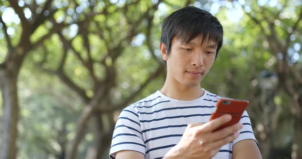 Young Man Use of Mobile Phone at Outdoor