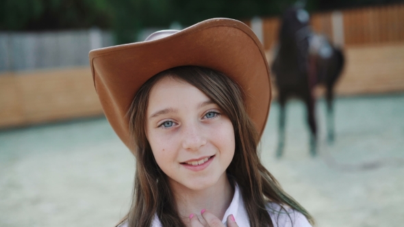 Portrait of Happy Girl Poses with Hat on the Horse Area