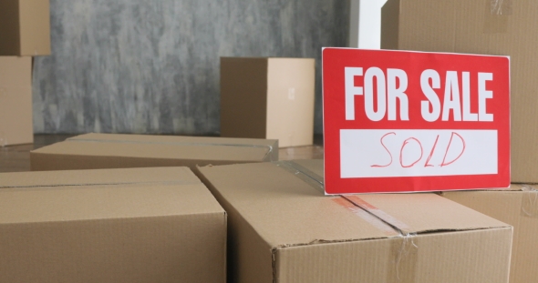 New Home Owners Unpacking Boxes. Moving Day Concept. Big Cardboard Boxes in New Home