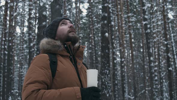 Man With Thermos In Winter Forest