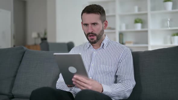 Shocked Young Man Having Failure on Tablet at Home