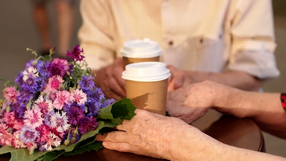 Elderly Couple Sitting in Cafe with Cups of Tea.