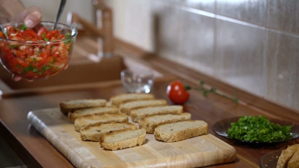 The Person Puts the Ingredients on Top of the Bread for Cooking Bruschetta