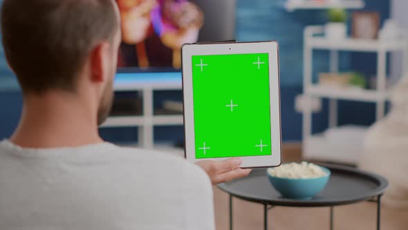 Closeup of Man Holding Vertical Digital Tablet with Green Screen in Online Conference or Group Video