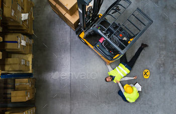 and her colleague lying on the floor next to a forklift. Aerial view.