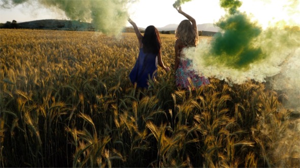 Girls Run in Wheat Field with Smokers