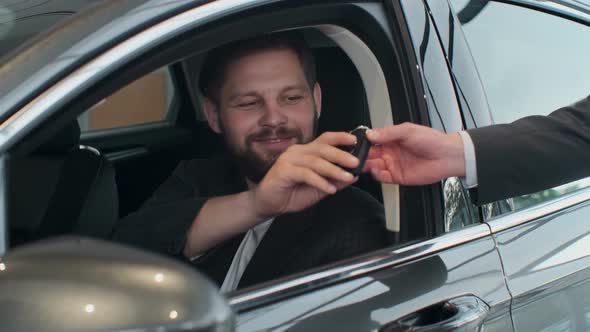 Sales Manager Handing Over the Keys To Man That Sitting in the Car