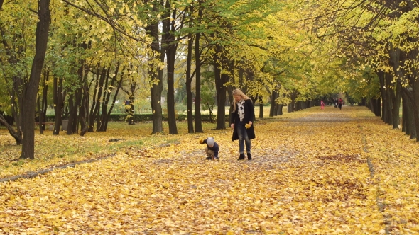 Mother and Son Walking in Autumn Park