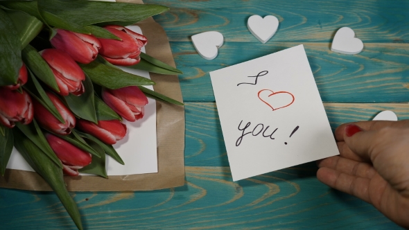 I Love You Message Note and Tulips Flowers Bouquet on a Wooden Table