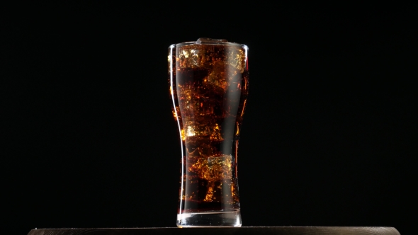 Large Glass of Cold Coke with Ice Cubes Rotating