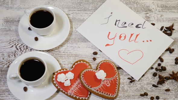 I Need You Message Note and Two Cups of Coffee with Heartshaped Ginger Biscuit on a