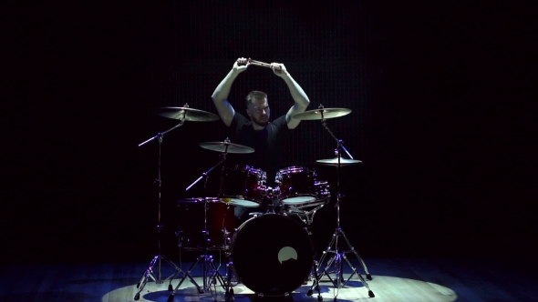 Drummer Playing on Drum Set on a Black Background