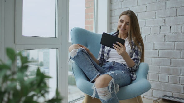 Young Smiling Woman Have Online Video Chat Using Digital Tablet Computer Sitting on Balcony in