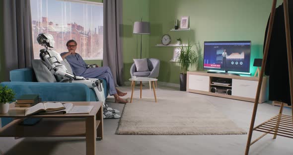 Middle Aged Man Watching TV with Android at Home