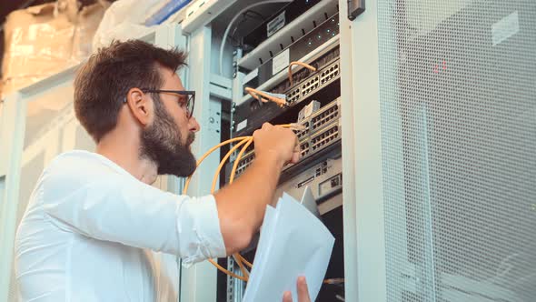 IT Engineer Patching Network Equipment In Server Room.Network Engineer in Big Data Center Mainframe