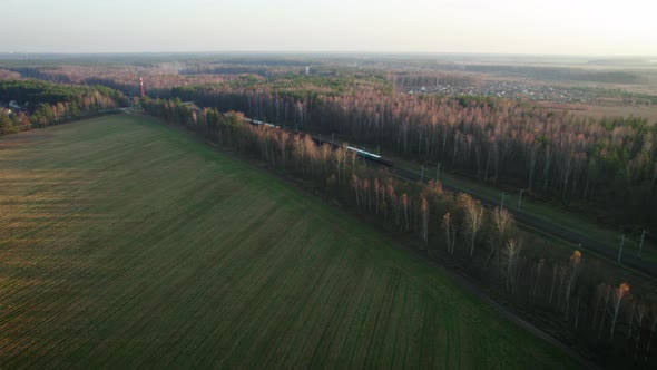 Freight Train Traveling By Rail in a Rural Wooded Area