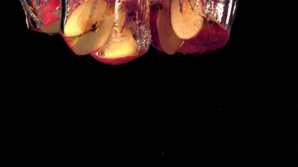 Super Slow Motion Sliced Apples Fall Under the Water with Splashes and Air Bubbles