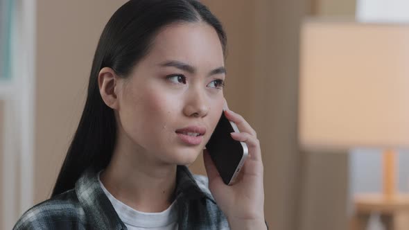 Portrait Asian Woman Millennial Confused Angry Girl Indoors Talking on Phone Answering Call Worries