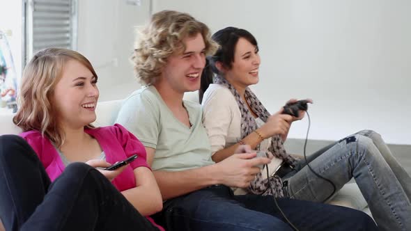 Three teenagers playing video game