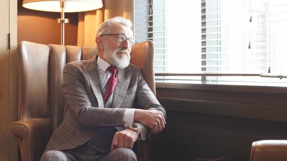 Toned Retro Styled Portrait of Businessman Sitting in Armchair at Office