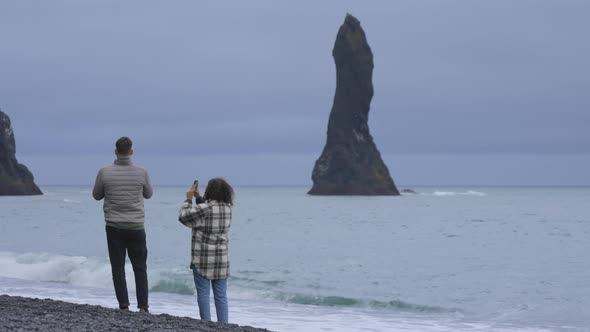 Travelers Appreciating the Scene By Taking Pictures on the Black Sand Beach