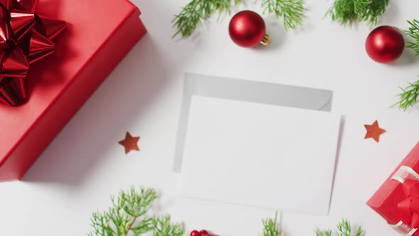 Video of red christmas decorations with envelopes on white background