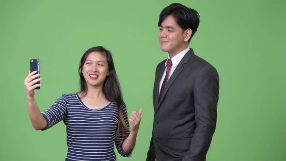 Young Handsome Asian Businessman and Young Asian Woman Working Together