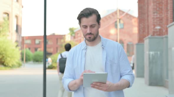 Man Using Tablet While Walking in Slow Motion