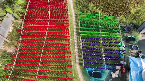 Aerial view of a person hanging to dry red cloths in Dhaka, Bangladesh.