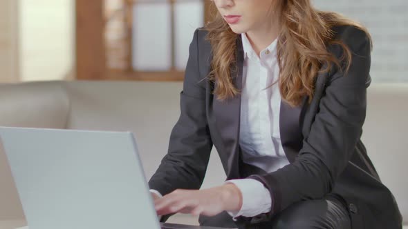 Businesswoman Sitting on Couch and Typing on Laptop, Preparation for Meeting